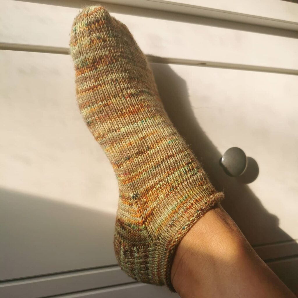 A foot wearing a short hand knitted sock